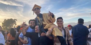 Graduate Freddy C. is lifted in celebration by his classmates