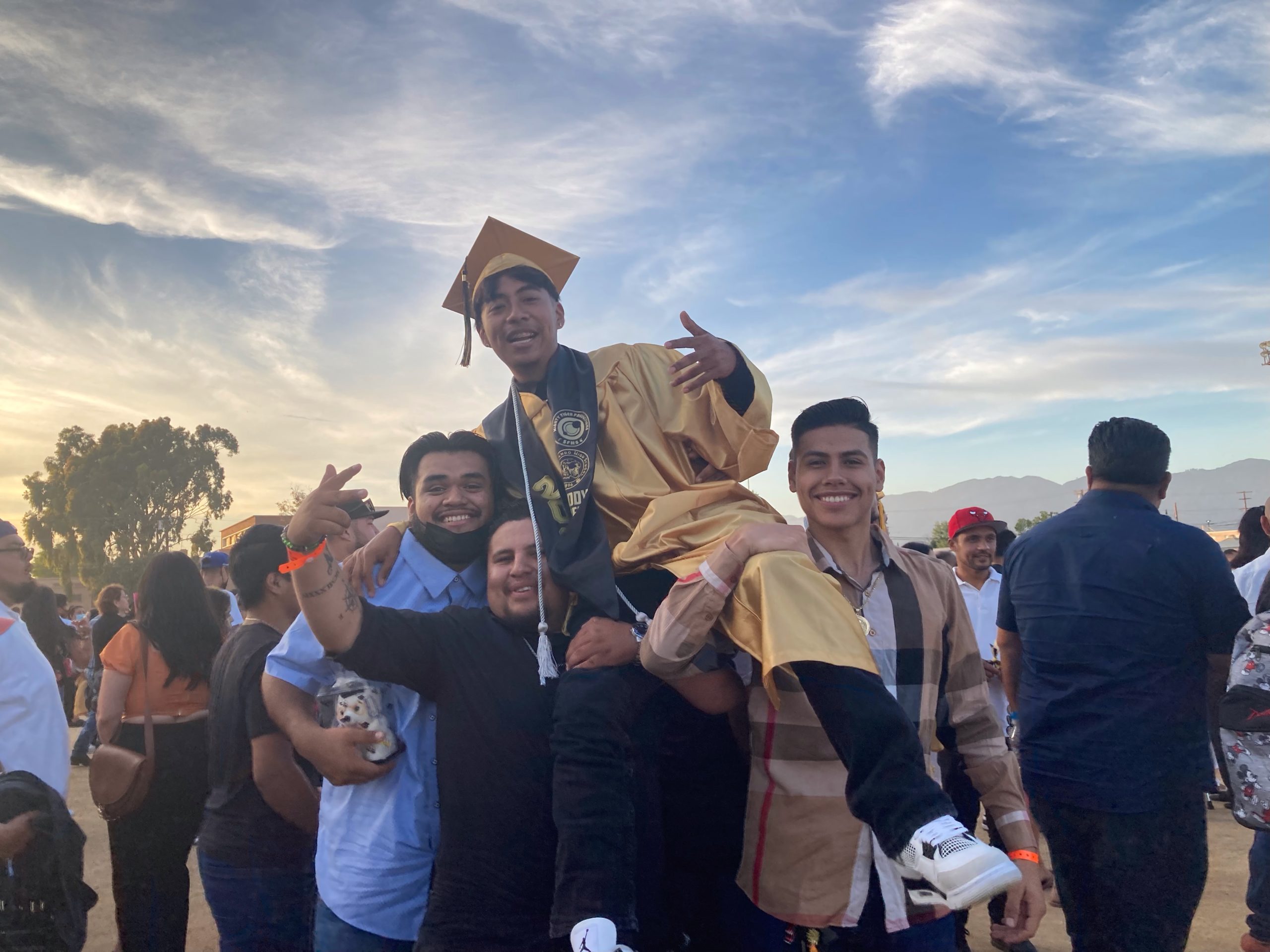 Graduate Freddy C. is lifted in celebration by his classmates