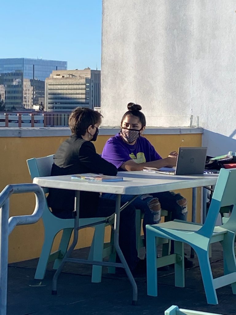 Tutor and student wear masks and study on Union Rescue Mission rooftop