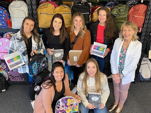 A group of women donating school supplies